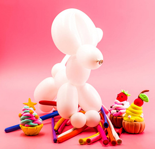 党的元素。派对工艺品可爱的白气球狗, 粘土蛋糕和气球在明亮的粉红色背景