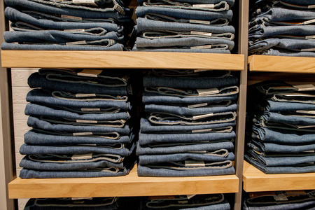 在商店货架上的牛仔裤裤。蓝色牛仔裤牛仔布收集牛仔裤堆积