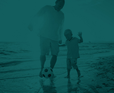 父亲和儿子在海滩概念玩游戏