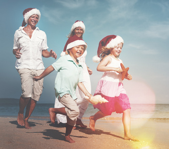 家人在海滩上圣诞老人的帽子