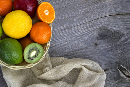 柑橘类水果，灰色的木制背景与亚麻餐巾篮子