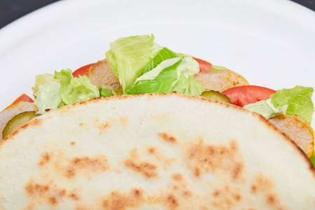 三明治裹着肉和蔬菜在白盘子上, 特写