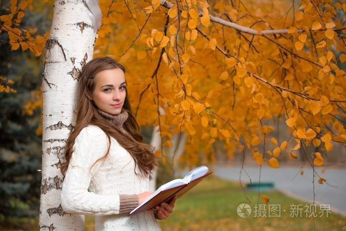 年轻漂亮的女人在秋天的公园