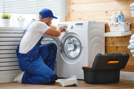 工作人水管工修理洗衣机在 laundr