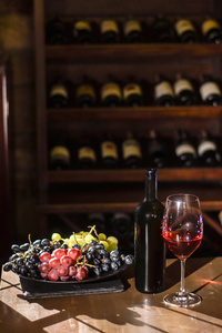 瓶的葡萄酒 酒杯和葡萄板放置在酒窖的木桌上