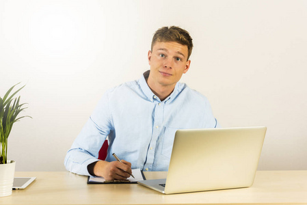 一个英俊年轻的微笑的人的肖像使用电脑笔记本电脑 b