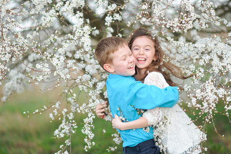 男孩和女孩在苍翠繁茂的花园里的肖像