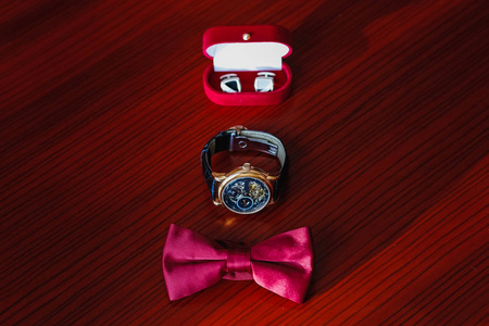 婚礼戒指, 手表和领结躺在桌子上