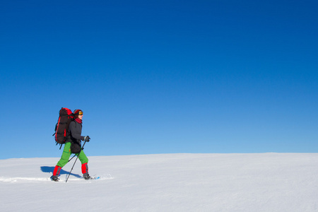 在山里徒步旅行带着背包和帐篷雪的冬天