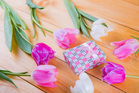 束嫩粉色郁金香与轻木背上的礼品盒