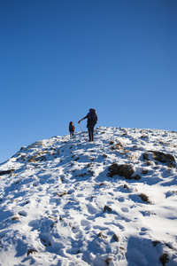 登山者爬在雪坡上