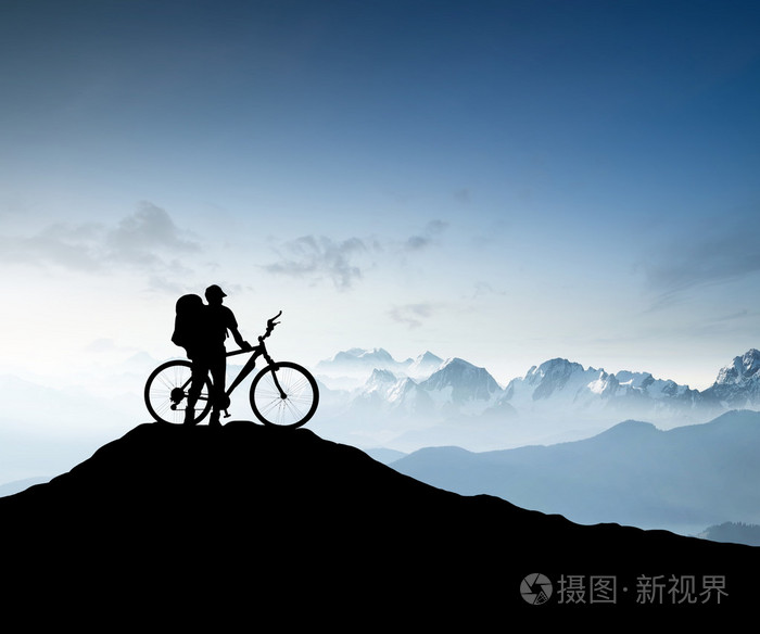 山峰上的自行车旅游的剪影