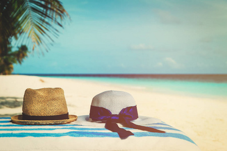 在热带海滩家庭度假的两顶帽子