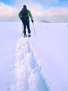 徒步旅行者在深漂移雪地行走的背包。在山中散步的人