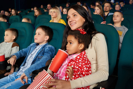儿童与父母正一起在电影院看电影