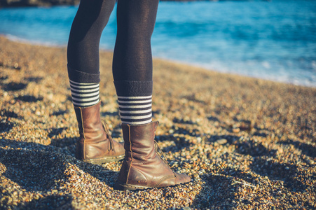 站在海滩上的年轻女子的双腿