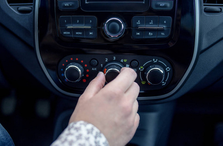 在现代汽车中的男性的手按下按钮
