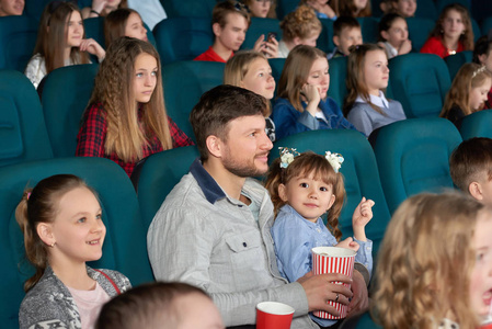 儿童与父母正一起在电影院看电影