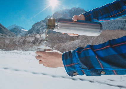 在一座雪山上手持一个热水瓶中的男子