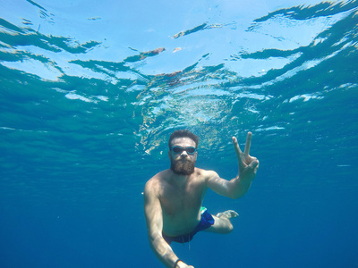 年轻的胡须男人，面罩潜水在干净的水