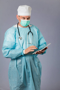医生用听诊器和脸上的面具拿着一台平板电脑