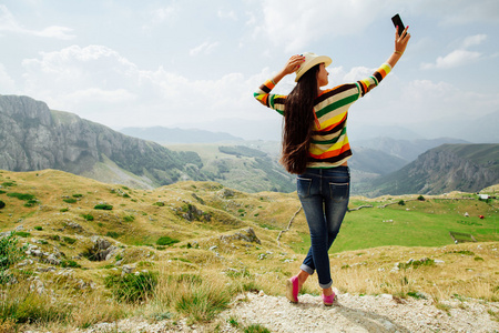 以智能手机在山中的自拍照照片长头发女孩