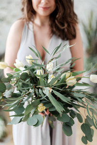 在新娘手中的桉树和郁金香的茂盛的花束