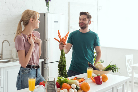 素食男友在厨房向女友赠送胡萝卜花束