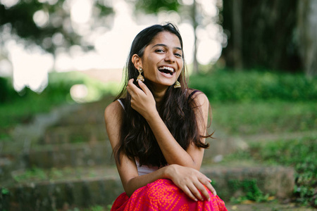 有吸引力的, 年轻的印度 亚洲 妇女的肖像坐在公园里的台阶上的一天