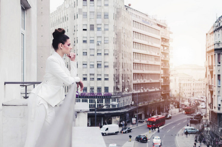 设计师白色西装在阳台上摆出的年轻女子