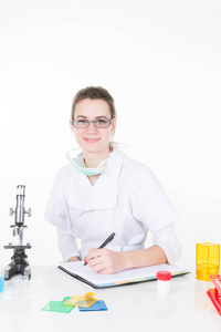 特写肖像, 年轻的微笑的妇女研究员科学家在白色实验室外套站在显微镜下