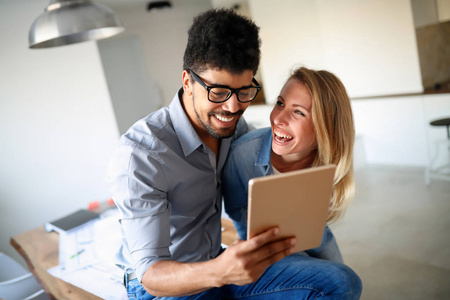 幸福的夫妇，在平板电脑在家里上网的爱