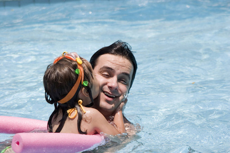 快乐的父亲和女儿在游泳池