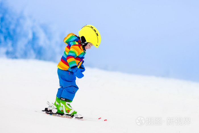 小孩在冬天在山上滑雪