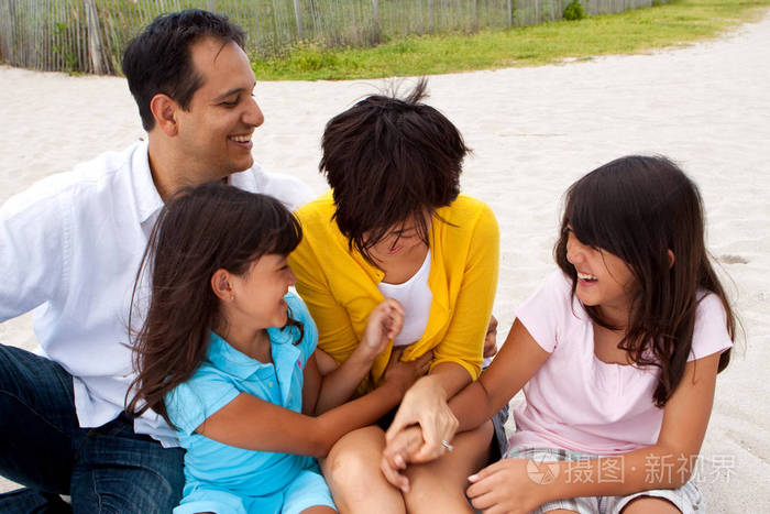 亚洲家庭在海滩上欢笑和玩耍