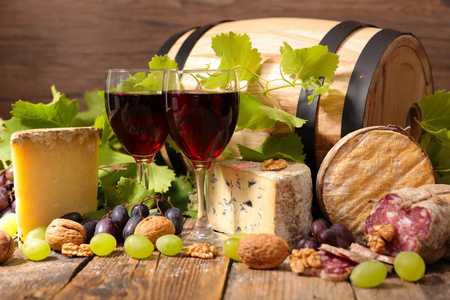 红葡萄酒杯和奶酪与桶在背景上图片