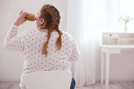 肥胖的年轻妇女消费垃圾食品图片