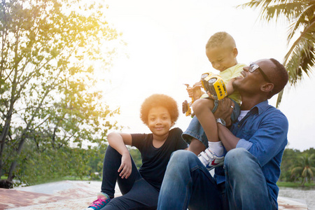 快乐的非洲裔美国父亲 儿子和女儿一起享受欢乐的时刻，在室外公园