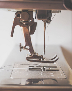 对缝纫机缝纫过程特写。压脚和针缝纫机操作期间