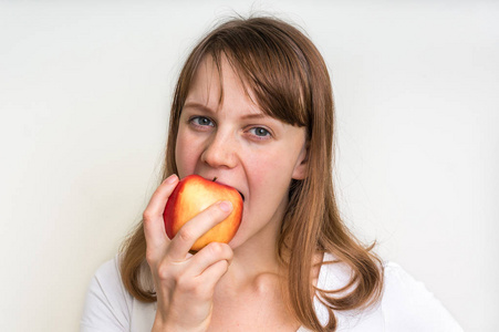 女人吃苹果上白色孤立