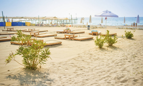 沙滩在蓝色海背景。在海边的雨伞和甲板椅。夏日沙滩休息。度假概念。在 Konakli 的晴朗的日子里看海边的海滩
