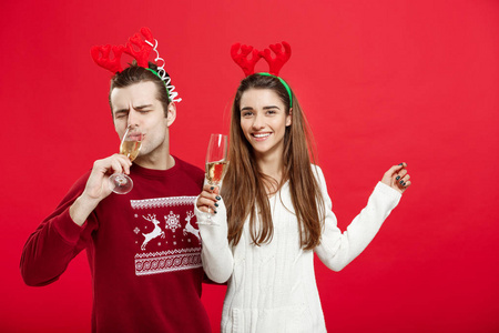 圣诞概念快乐的年轻夫妇在毛衣庆祝圣诞节与香槟
