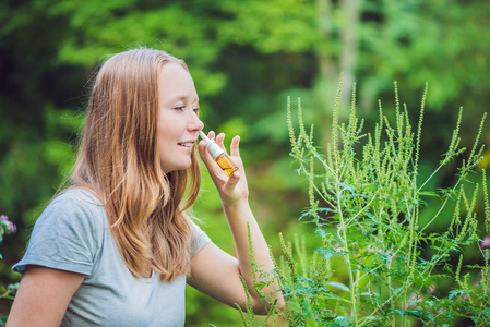 年轻的女人，由于对豚草过敏使用喷雾过敏