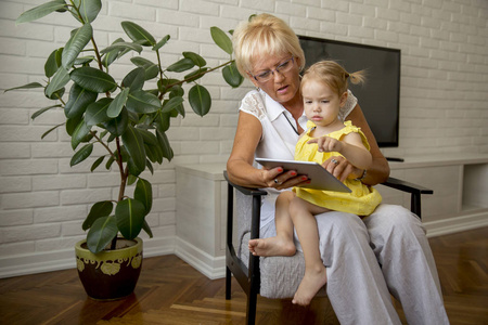 祖母和小孙女在家里看书快乐