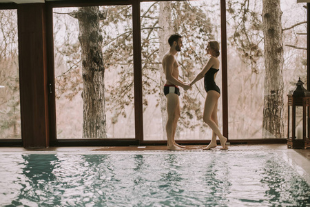 爱的情侣在泳池边的水疗中心放松身心
