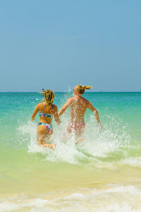夫妇在沙滩上热带度假村旅游