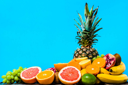 夏季背景水果, 热带新鲜水果, 多汁桔子, 切片普通话, 葡萄柚和菠萝在蓝色背景