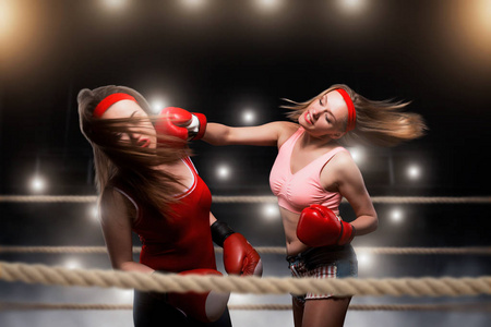 两个女 kickboxers 在拳击场上打架