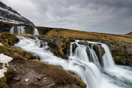 冰岛 Snaefellsnes 半岛北部海岸背景下的 Kirkjufellsfoss 瀑布顶部的令人惊叹的冰岛景观 Kirkju