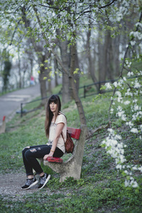 公园外面美丽的年轻女子。白人女孩, 长棕色头发坐在长椅上的浪漫姿势